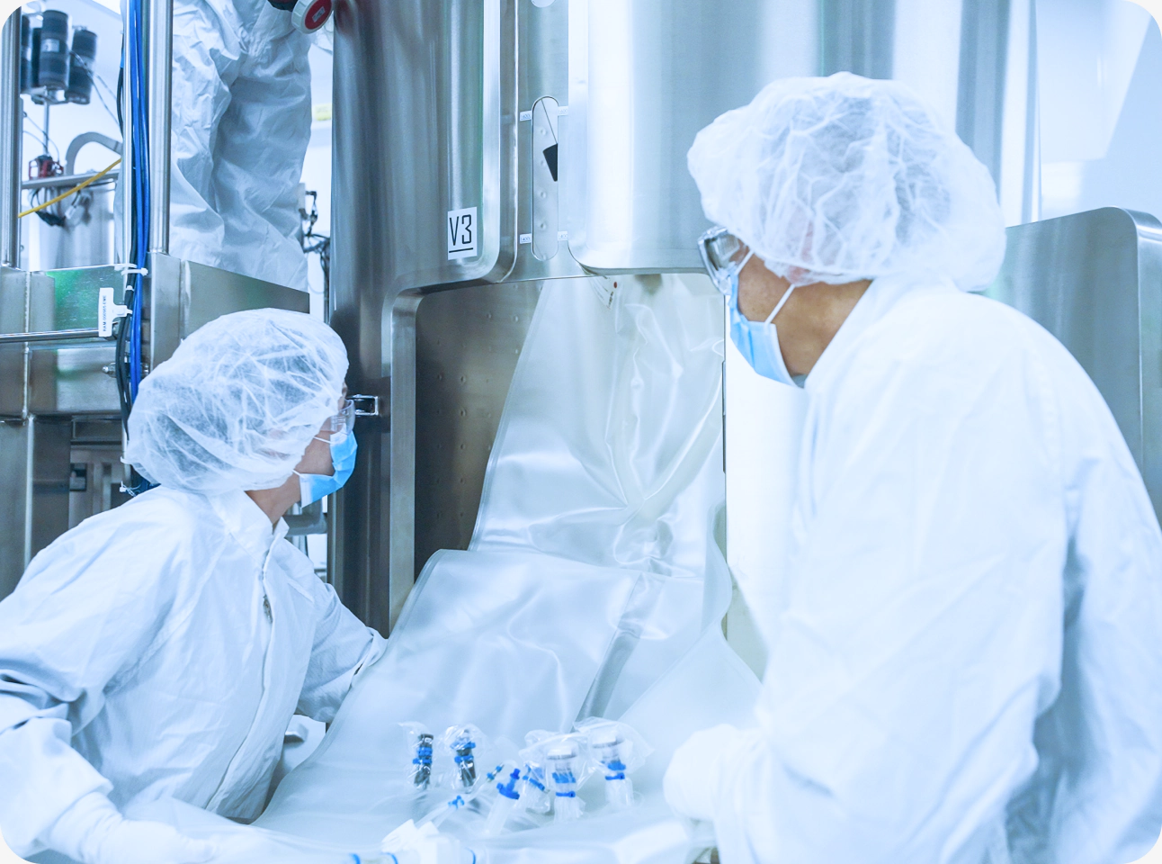 Two technicians working with stainless-steel bioprocess equipment