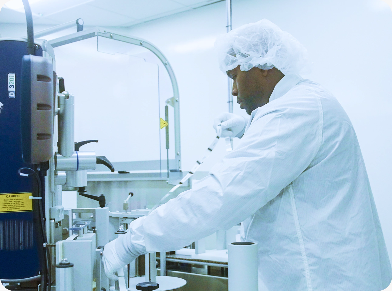 A cleanroom technician operating packaging and labeling equipment