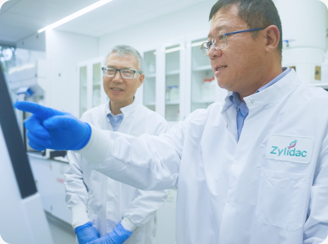 Two scientists reviewing process information on laboratory equipment